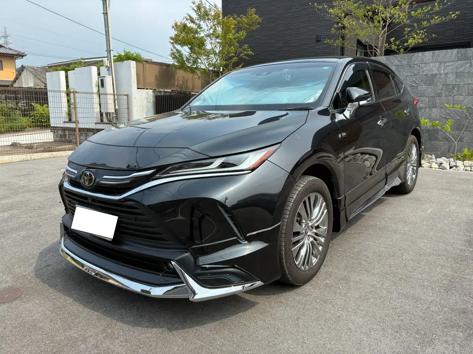 ハリアー買取事例_2021年式 | 車買取のソコカラ Black Toyota SUV parked on pavement, front-left angle showing chrome grille and sleek headlights.